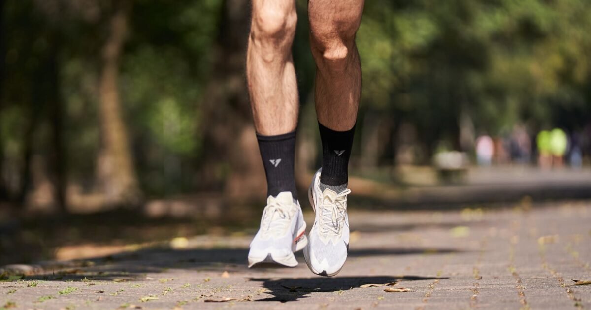 Close-up of a jogger's feet in mid-air on a sunny day in the park.