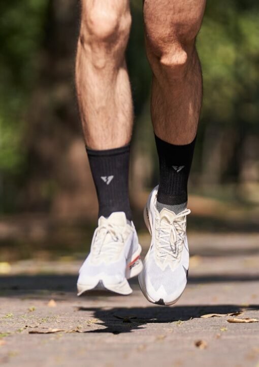 Close-up of a jogger's feet in mid-air on a sunny day in the park.
