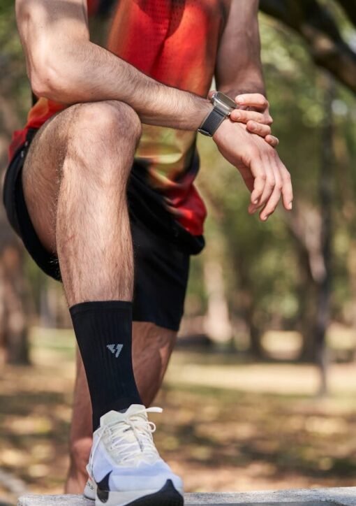 Close-up of an athlete resting on a park bench, emphasizing fitness gear and smartwatch.