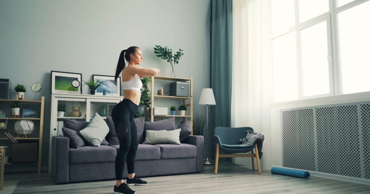 a woman standing in a living room in front of a window