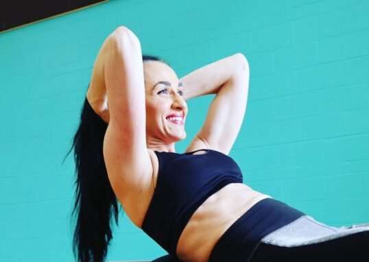 woman in black tank top and gray leggings doing yoga