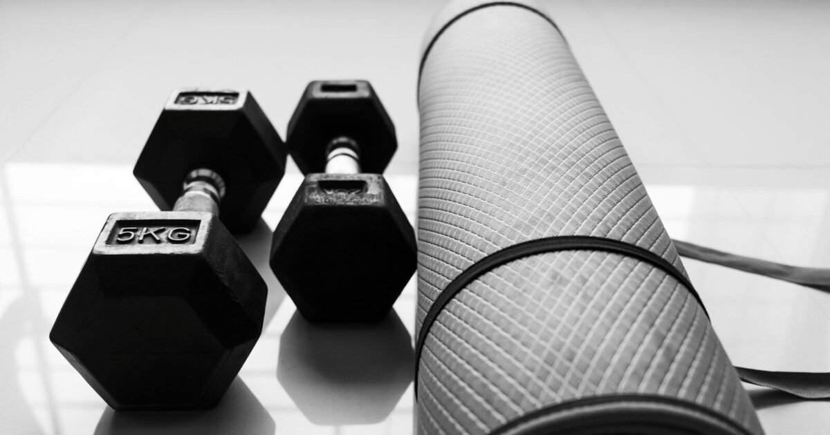 a black and white photo of dumbbells and a yoga mat