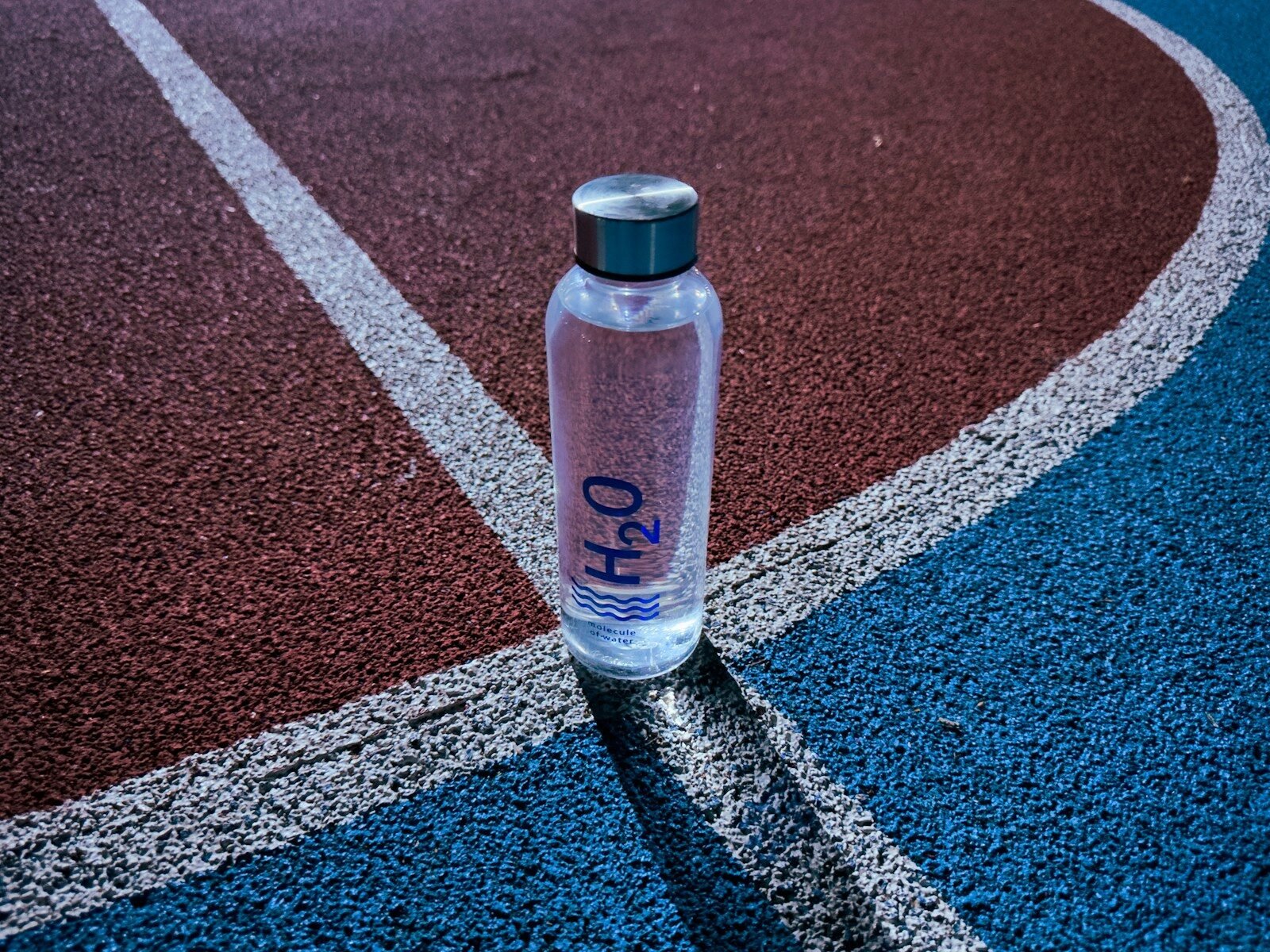 a bottle of water sitting on a tennis court