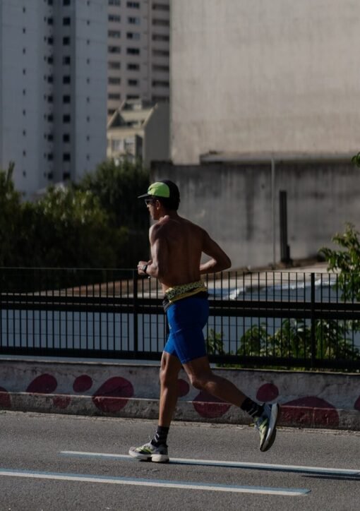 A shirtless man running on a city street