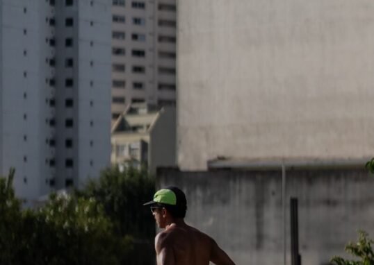 A shirtless man running on a city street