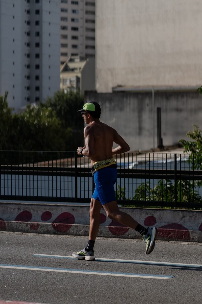 A shirtless man running on a city street