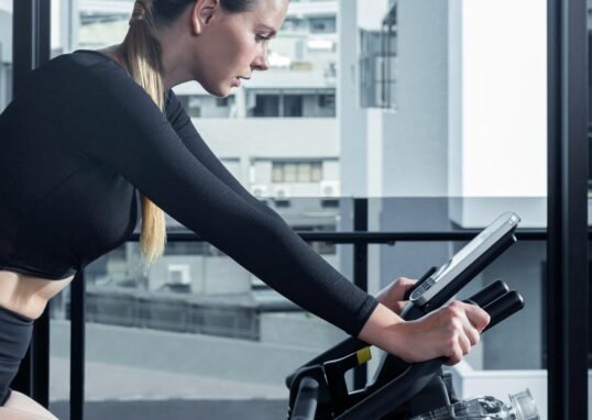 a woman on a stationary bike using a tablet