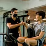 Trainer and client fist-bumping at the gym.