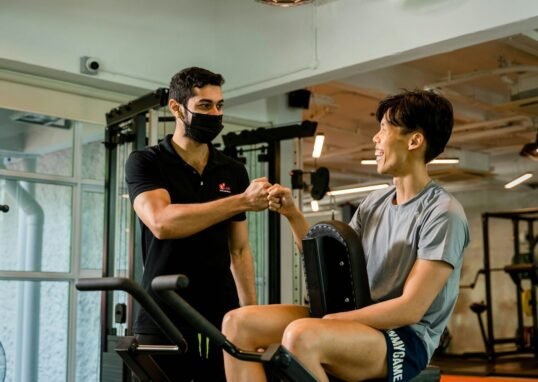 Trainer and client fist-bumping at the gym.