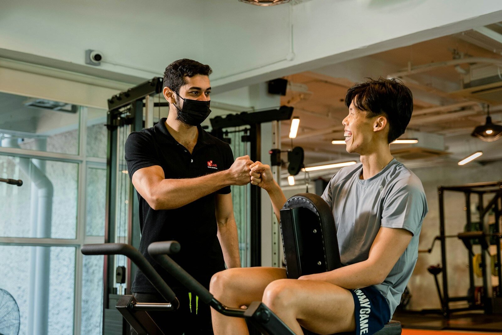 Trainer and client fist-bumping at the gym.