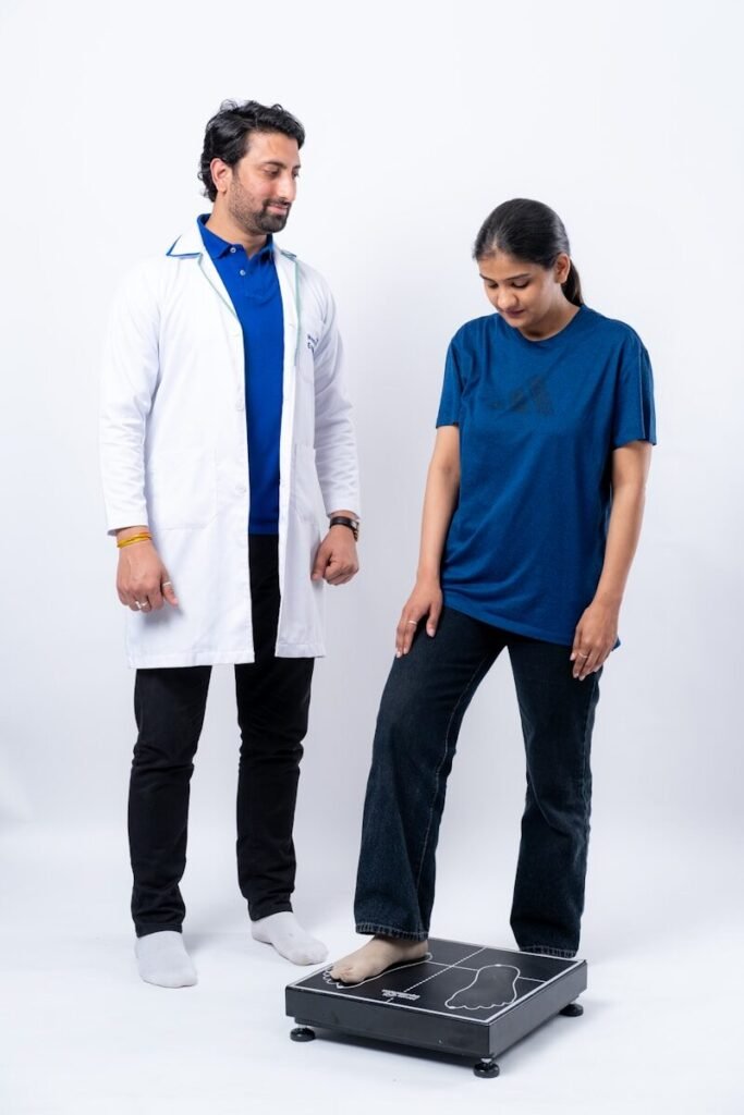 Médico avaliando paciente em balança de bioimpedância para medir massa magra e gordura visceral.