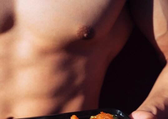 person holding black plastic container with food