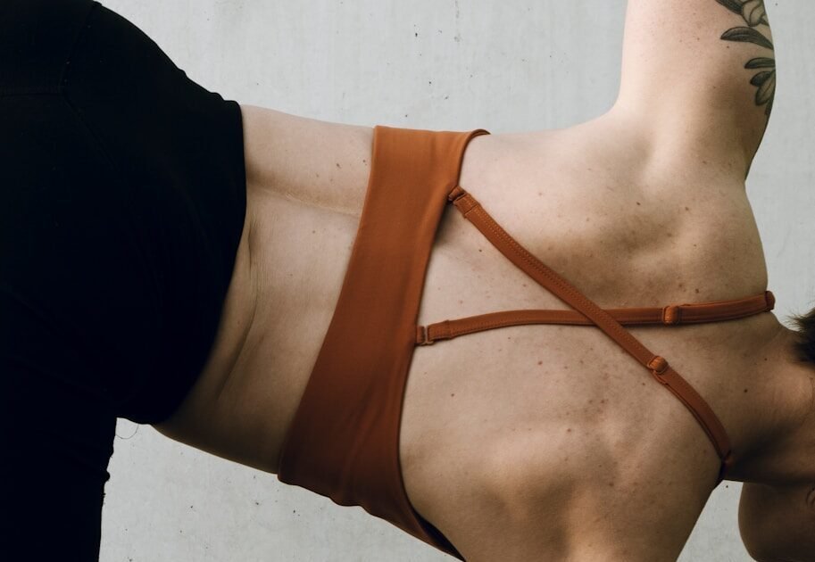 a woman in a brown bikini doing a handstand