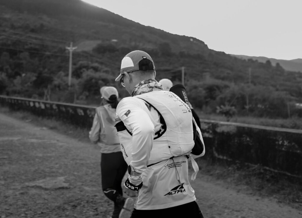 Runners on a dirt path with a hill background