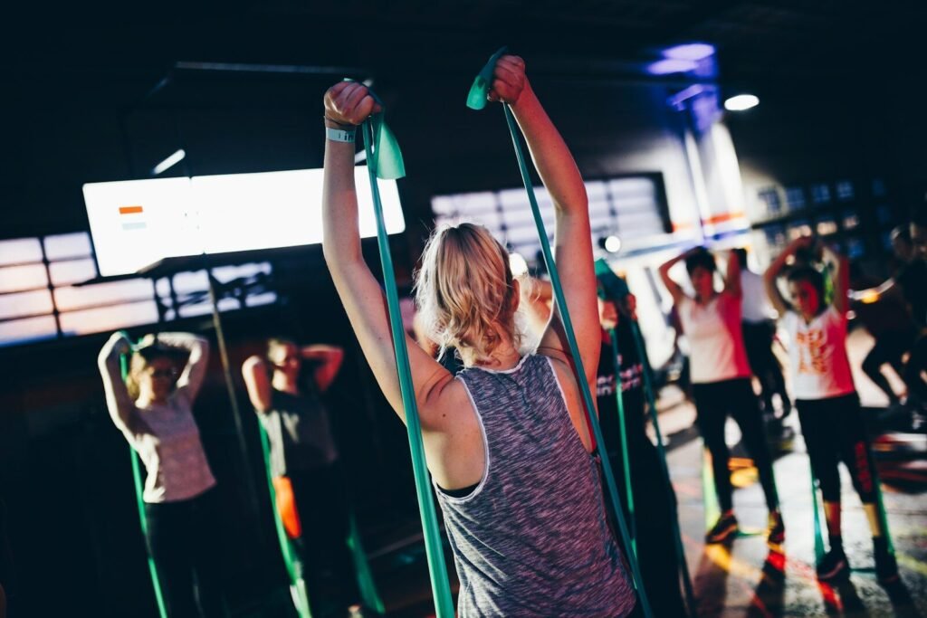Grupo de pessoas em uma academia realizando exercícios com mini bands.