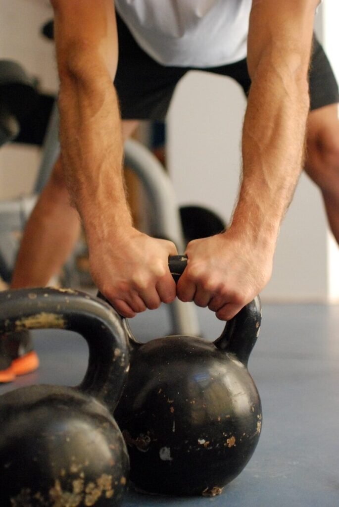 Homem praticando treino com kettlebell em casa para ganhar força e resistência