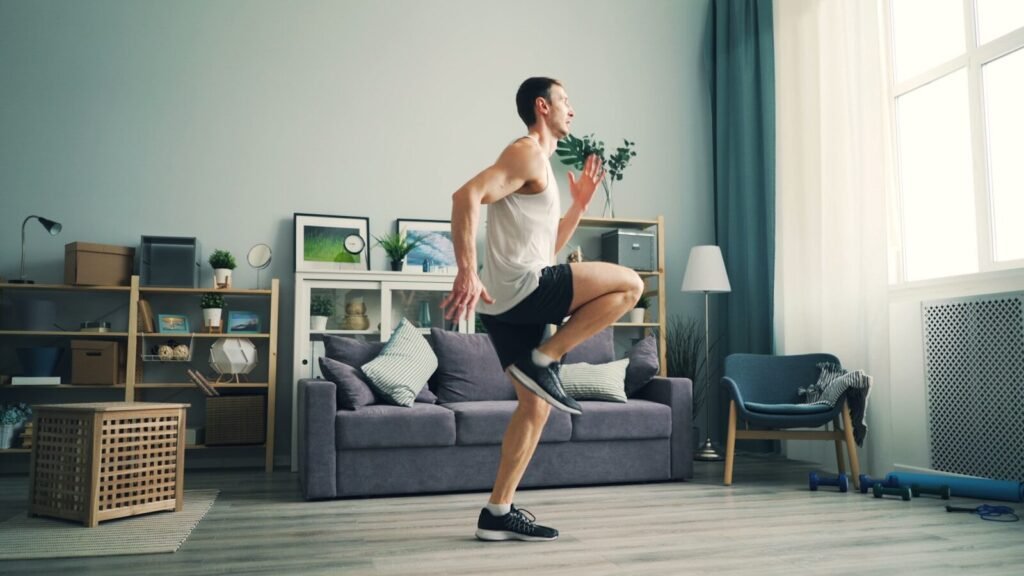 Homem praticando movimentos de mobilidade em casa como parte do treino funcional para iniciantes.