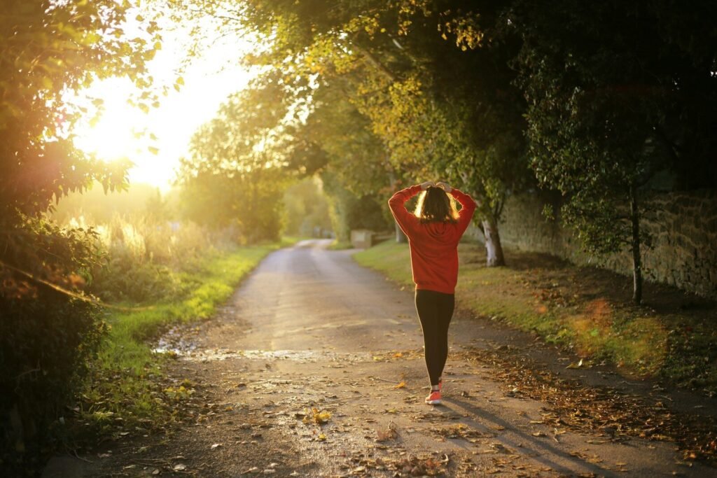 Caminhada emagrece mesmo? Mulher praticando caminhada em terreno variado para queima calórica.